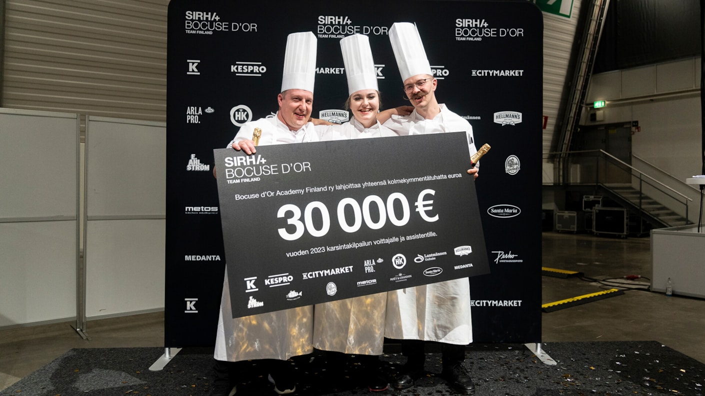 Sipeläisen kisajoukkue poseeraa valkitoshekin kanssa Bocuse d'Or kisojen jälkeen.